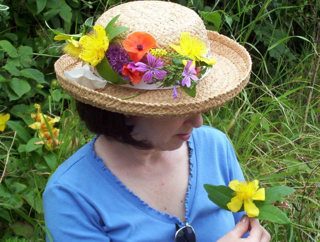 An image of Jean holding a Rose of Sharon or Aaron's Beard a flower growing wild near Stonehenge in Wiltshire, England. Photography by Frame To Frame - Bob and Jean