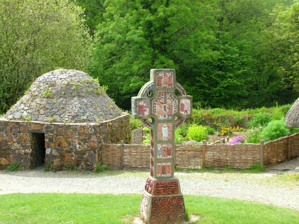 a Christian High Cross and beehive dwelling at Irish National Heritage Park, Ireland