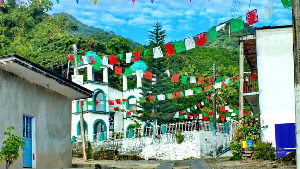 Image of red, white and green banners gaily strewn overhead in the town of La Bajada, Mexico.
