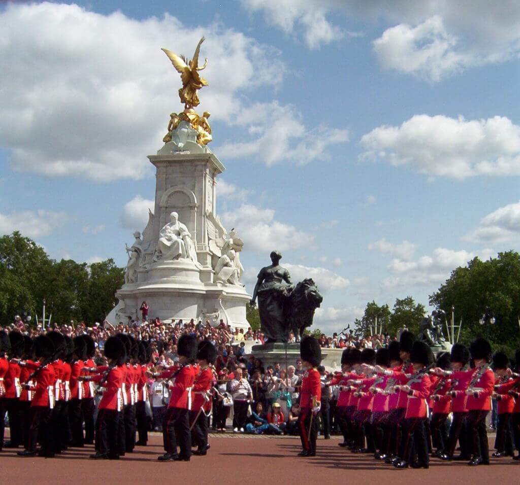 guardsmen in front of the victoria memorial, buckingham palace, london, england