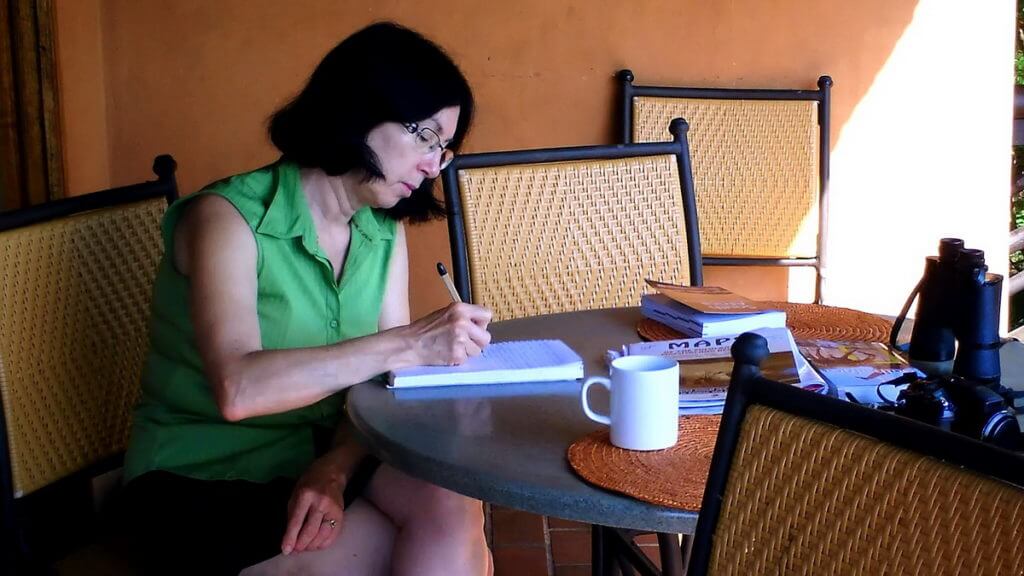 jean writing her diary at hilltop camp, hluhluwe-imfolozi, south africa