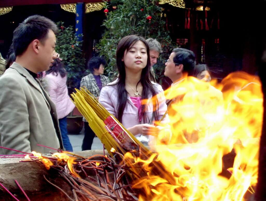 People conduct ceremonies of worship inside the City God Temple of Shanghai, in China.