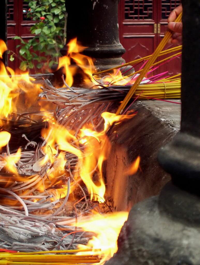 Burning incense sticks in the burning pit inside the City God Temple of Shanghai.