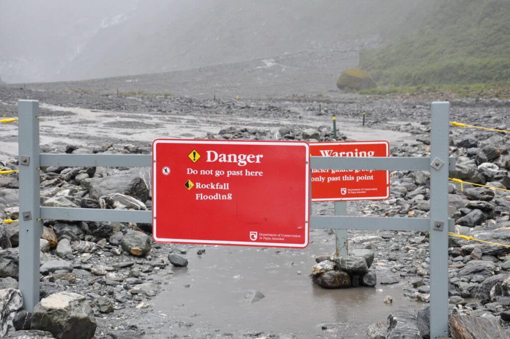 warning signs at fox glacier, south island, new zealand