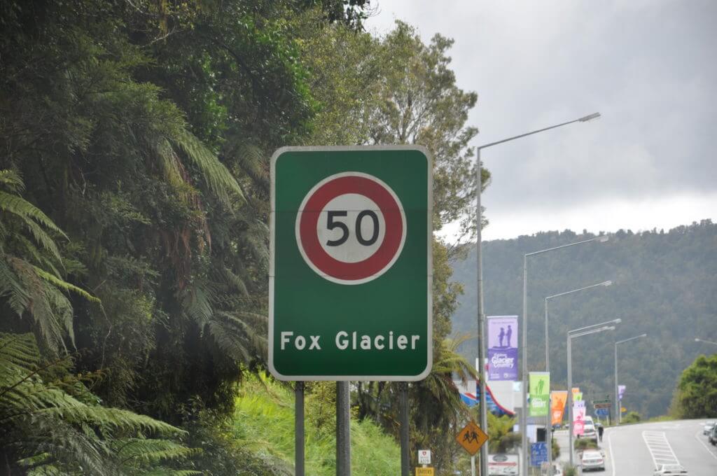 a sign for fox glacier, south island, new zealand
