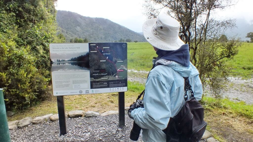 jean looking at a trail map, lake matheson, south island, new zealand
