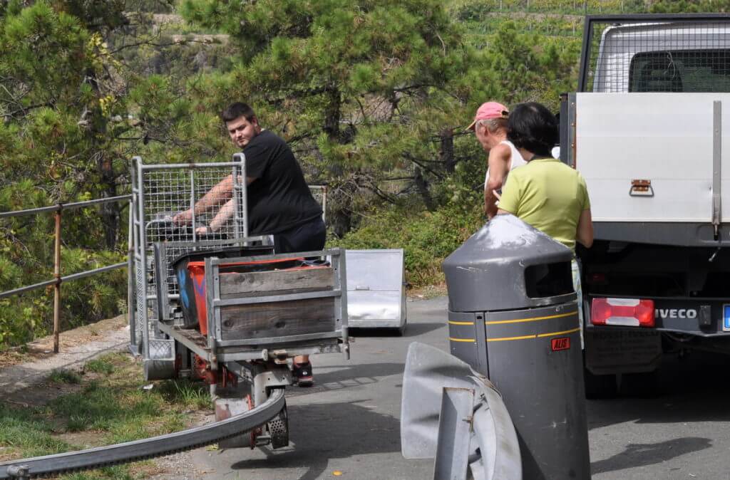 workers unloading a monorail, cogwheel railway, cinque terre, italy
