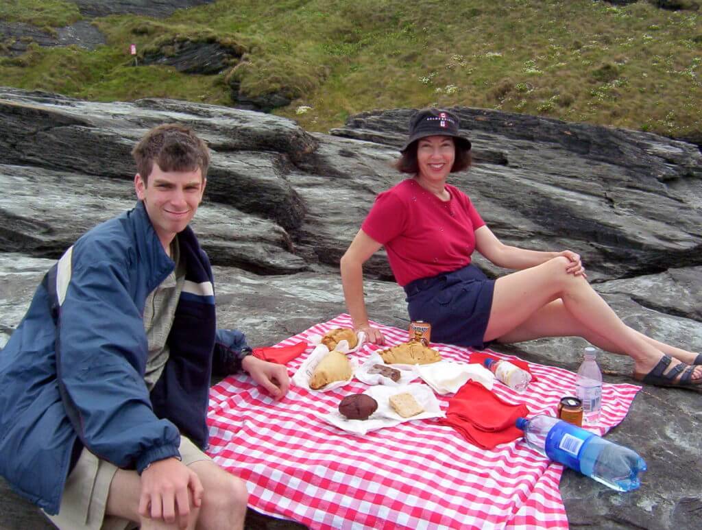 jean and her son picnicking at trebarwith strand beach, cornwall, england