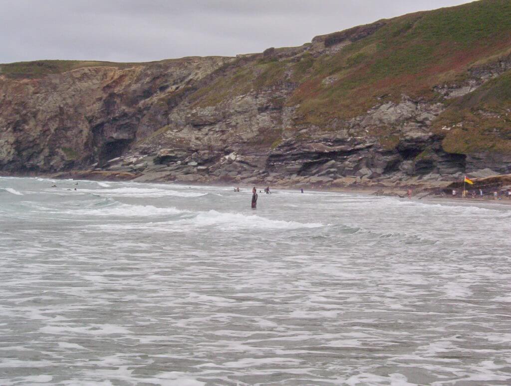 swimmers at trebarwith strand beach, cornwall, england