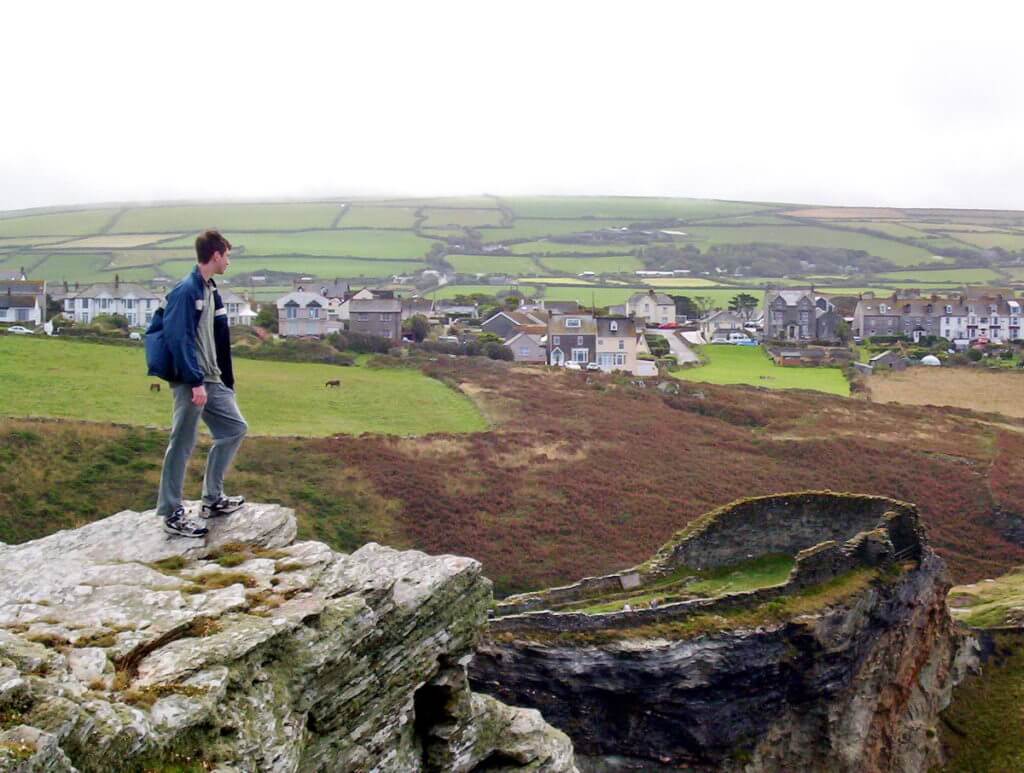 young lad looking at tintagel castle, cornwall, england