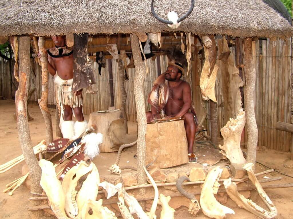 zulu men in a shelter with animal bones, shakaland, kwazulu-natal, south africa