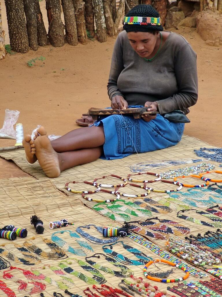 a zulu woman doing beading, shakaland, kwazulu-natal, south africa