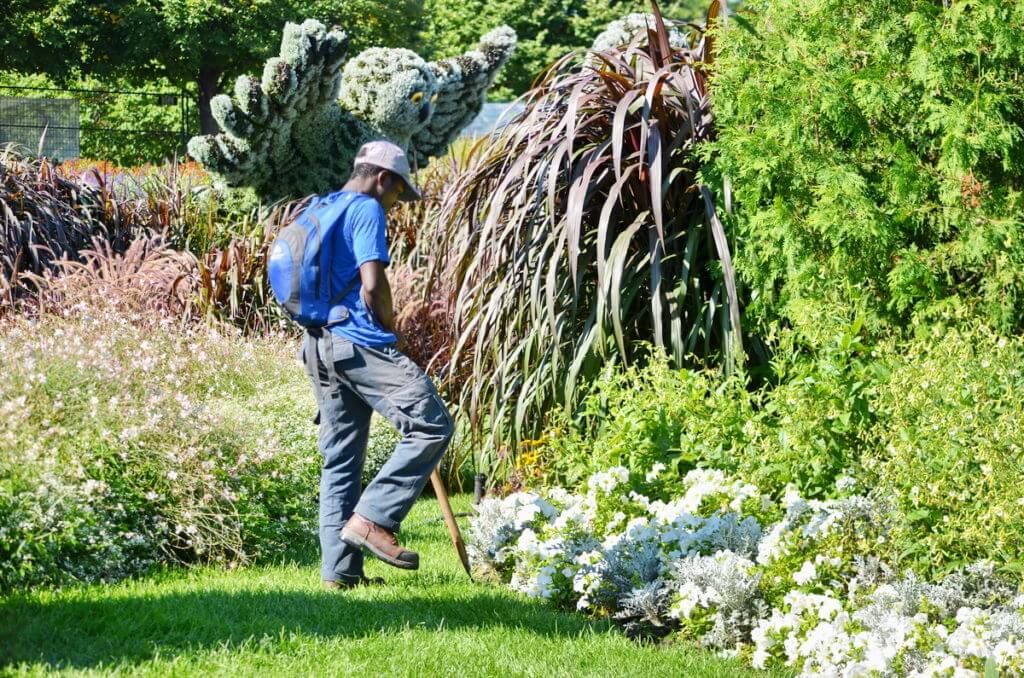 a gardener edging a garden, mosaiculture 2018, gatineau, quebec, canada
