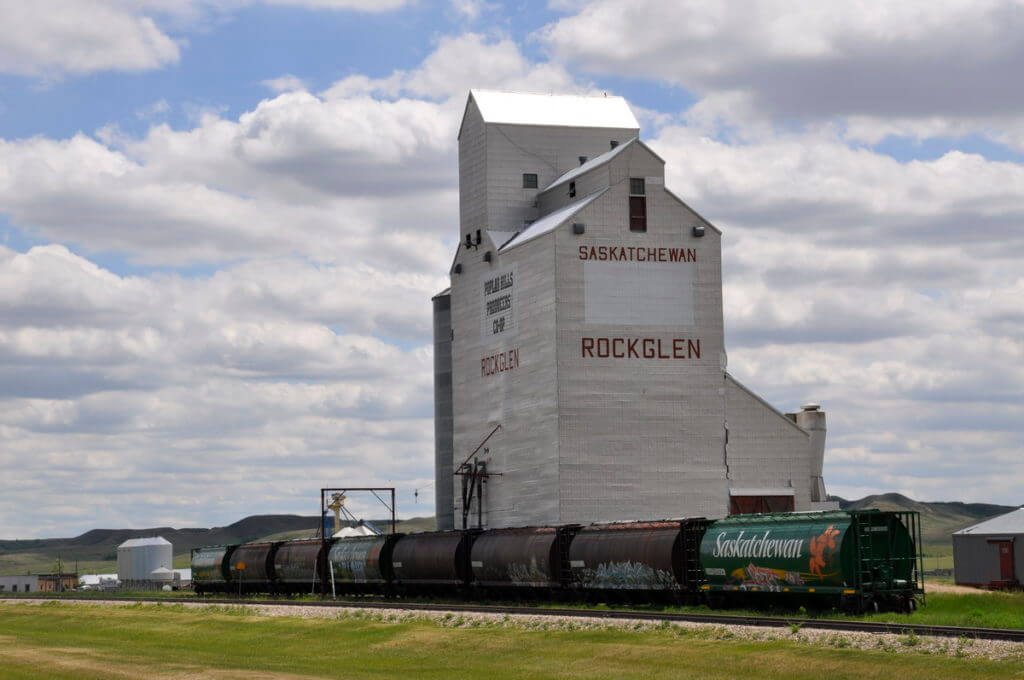 a grain silo and waiting train, rockglen, saskatchewan