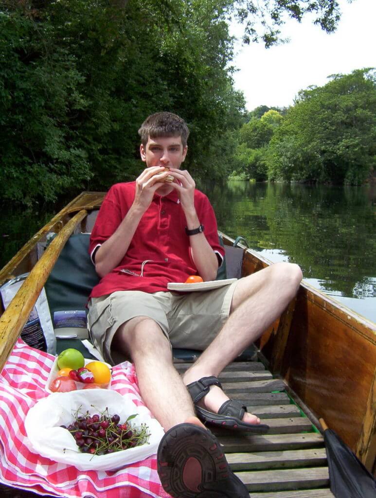 a person picnicking in a punt, avon river, bath, england