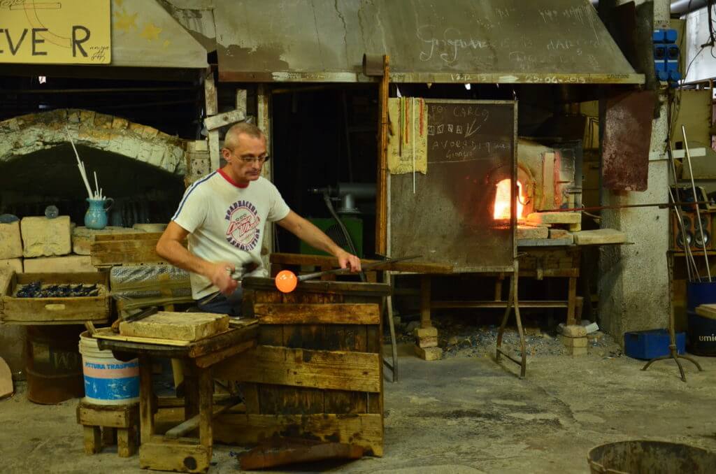 an artisan with a blow pipe and bubble, gino mazzuccato glass factory, murano island, venice, italy