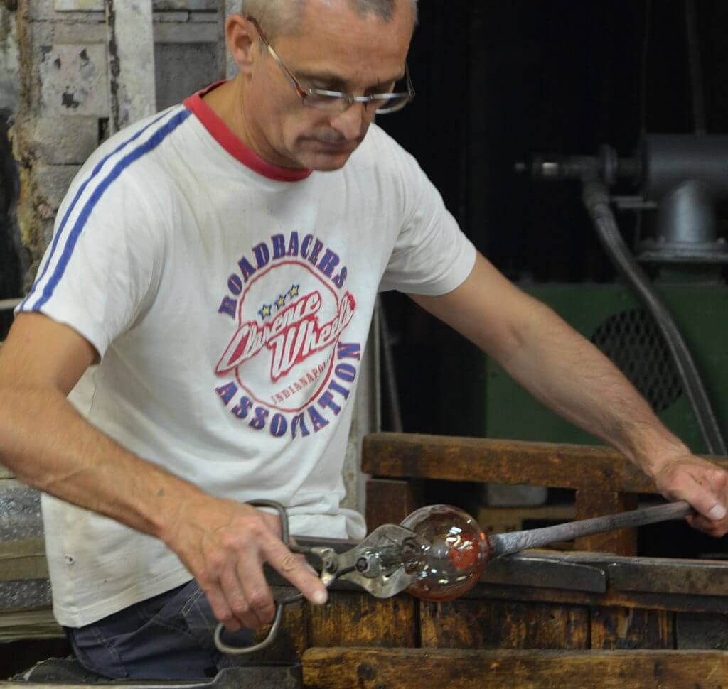 an artisan with giant glass-cutting clippers, gino mazzuccato glass factory, murano island, venice, italy