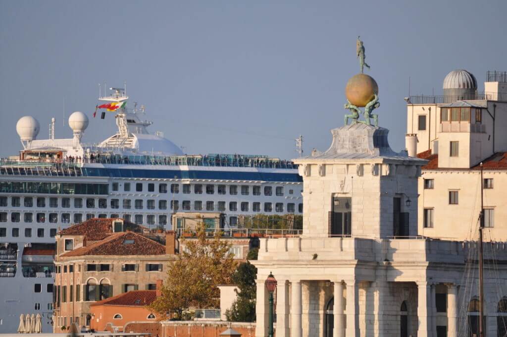 a cruise ship dwarfing sant maria della salute, giudecca canal, venice, italy