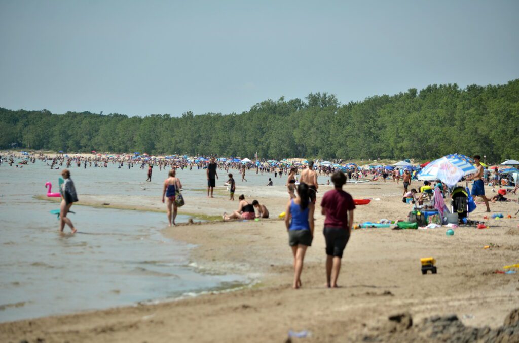 image of crowded sand beach at sandbanks provincial park, ontario