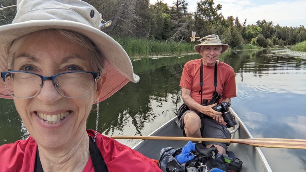 image of bob and jean in the canoe on the outlet river in sandbanks provincial park, ontario
