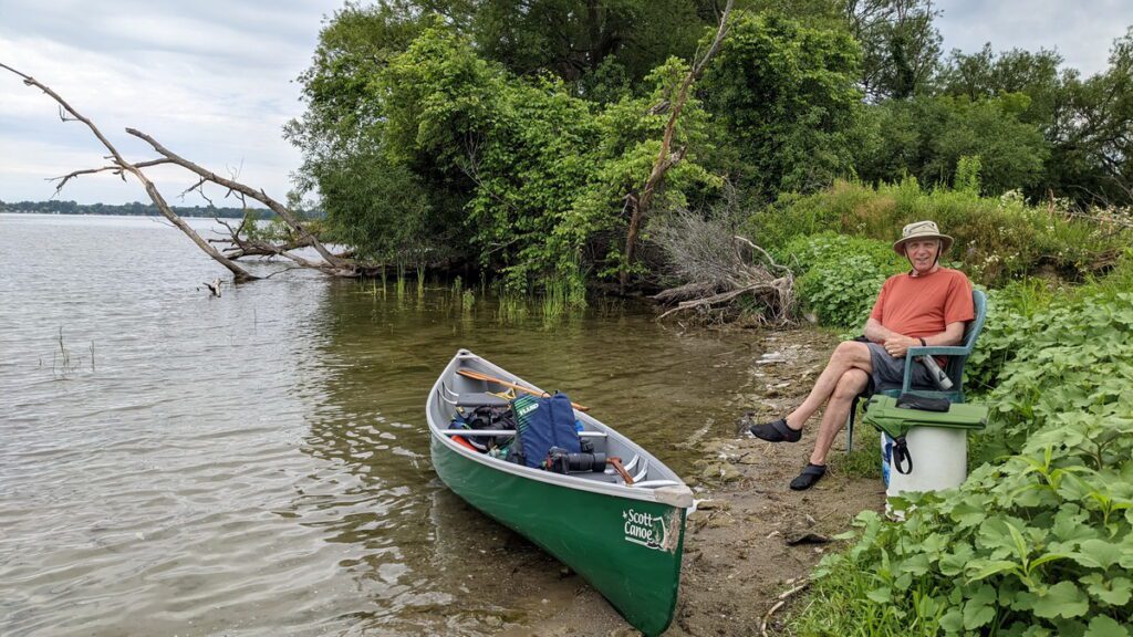 image of bob seated on the shore of east lake, sandbanks provincial park, ontario