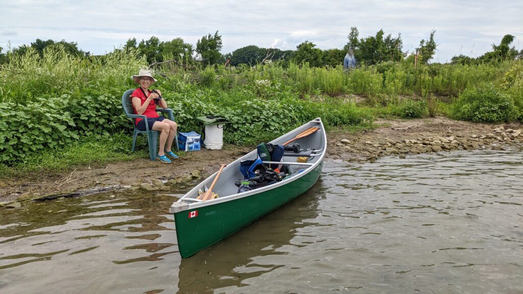 image of jean sitting on the shore of east lake, sandbanks provincial park, ontario