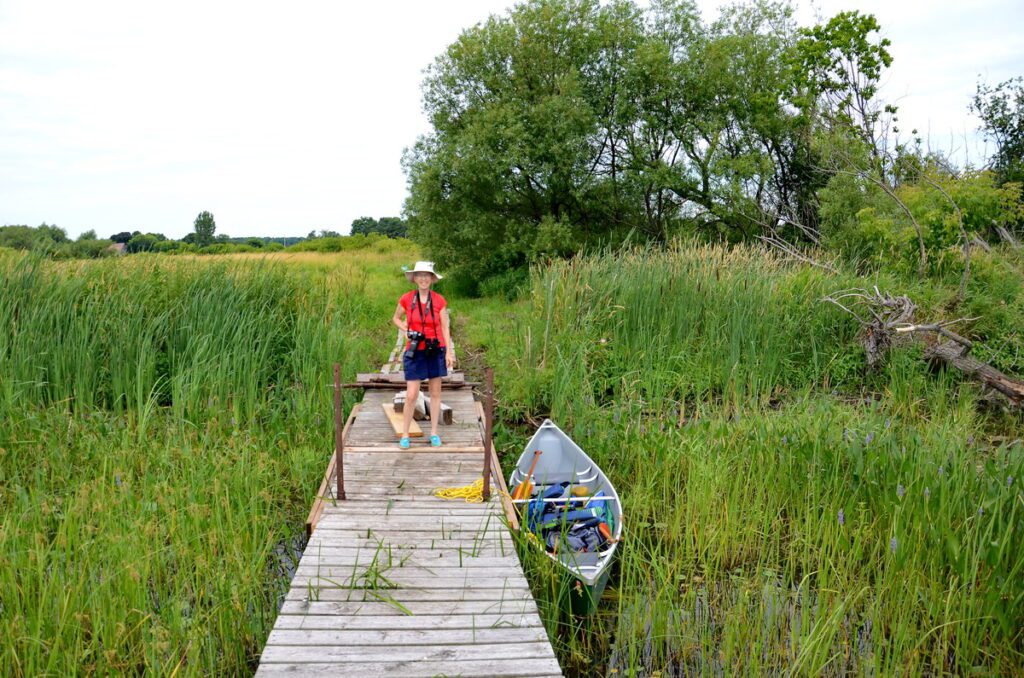 image of jean standing on a dock along east lake, sandbanks provincial park, ontario