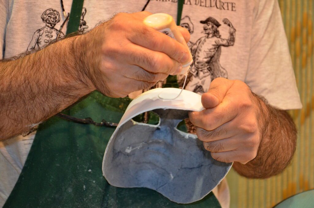 image of a mascherari making a volto mask, venice, italy