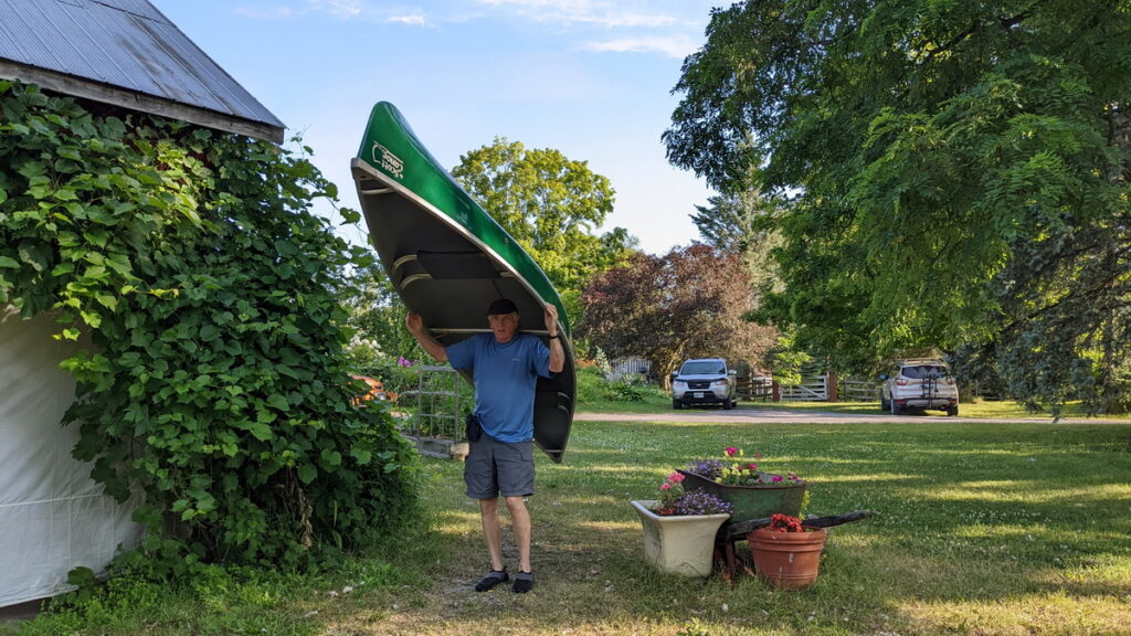 image of bob carrying a canoe, black river, prince edward county, ontario