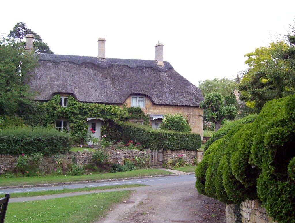image of a thatched cottage and manicured hedge, chipping campden, england