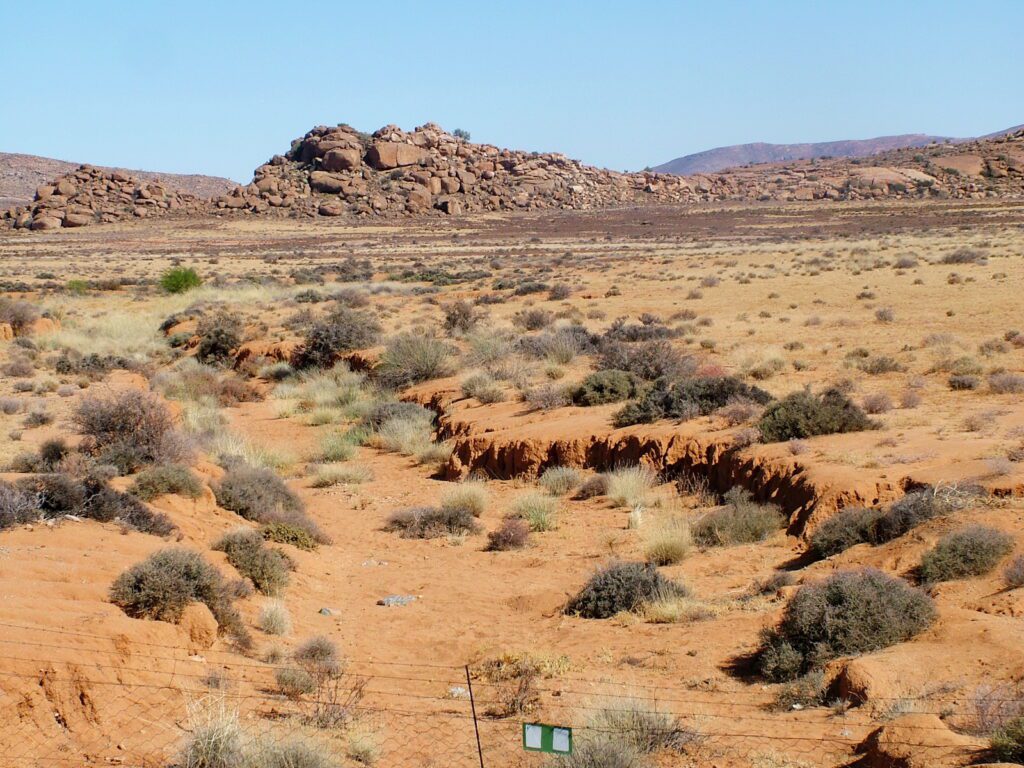 image of red soil and piles of rock, the highveld, northern cape, south africa