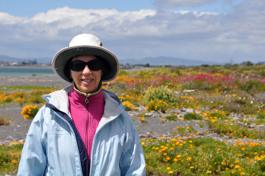 an image of jean among vibrant flowers on the beach, hawke's bay, napier, new zealand