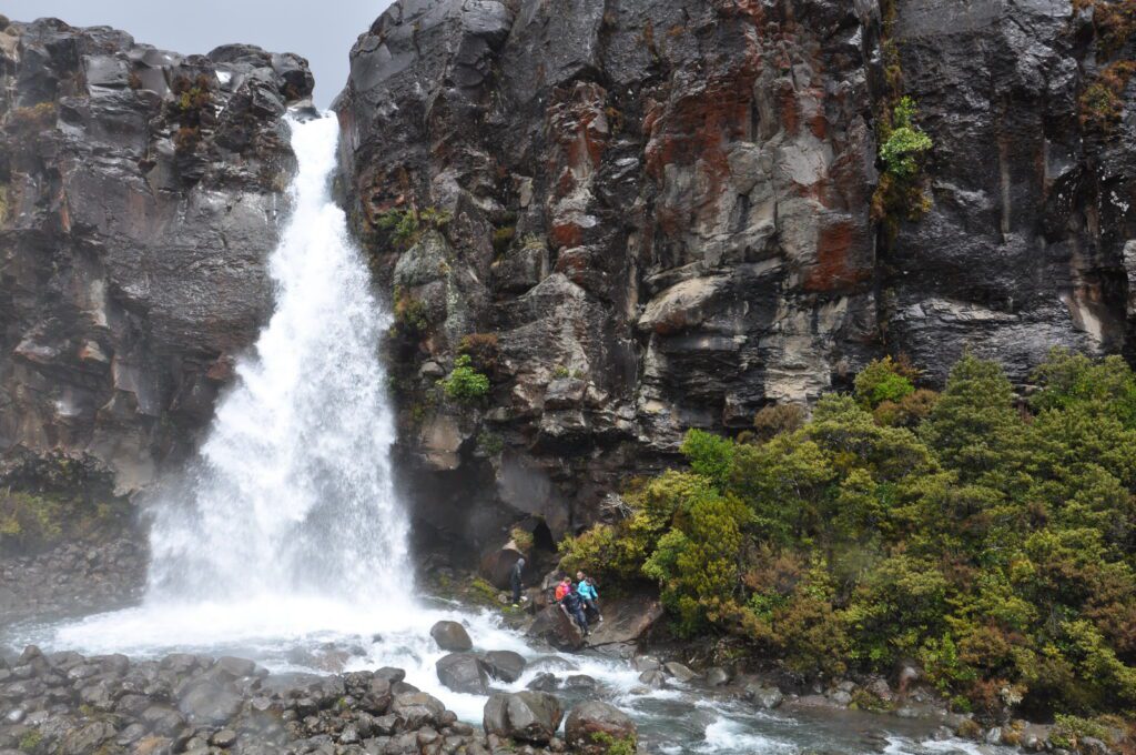 image of people at the base of taranaki falls, Mt. Tongariro National Park, New Zealand