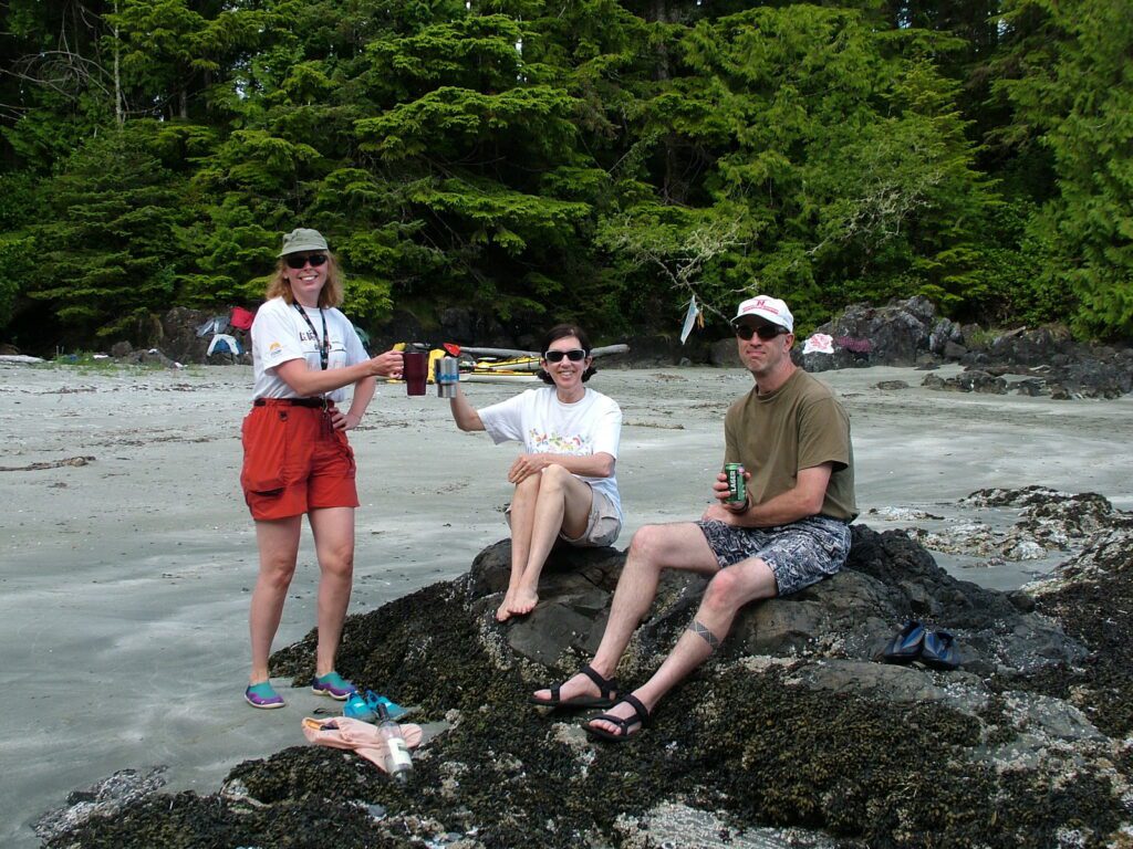 image of people sitting on a rock, ahous bay, vargas island, british columbia 