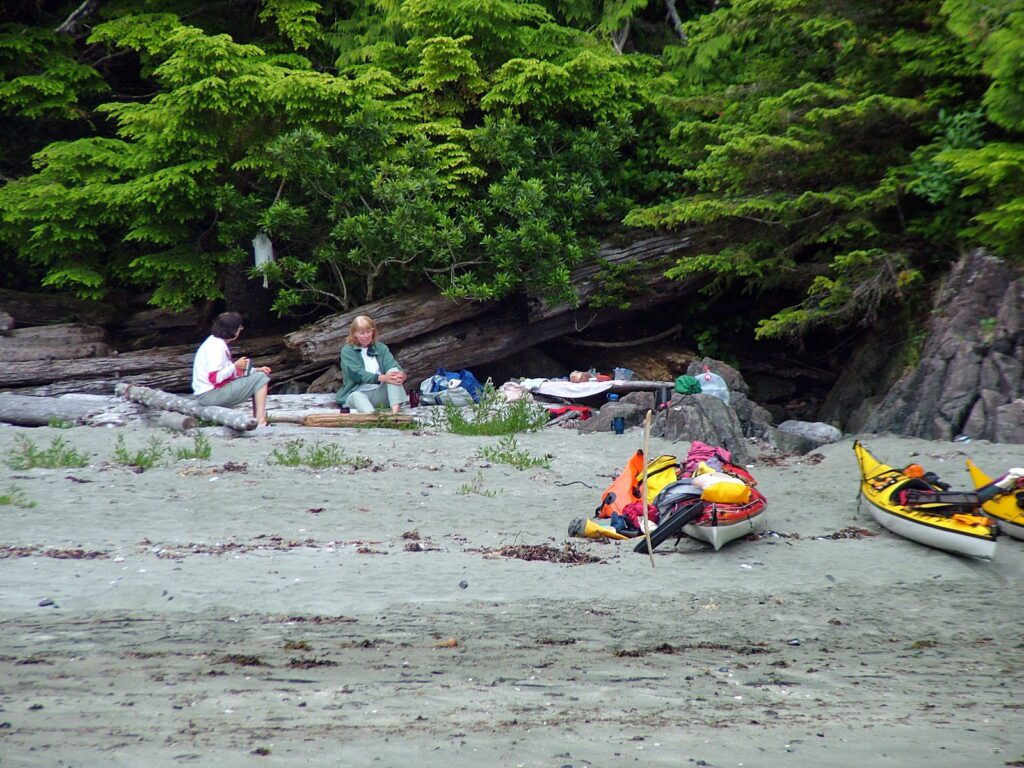 image of jean and claire sitting on logs, ahous bay, vargas island, british columbia