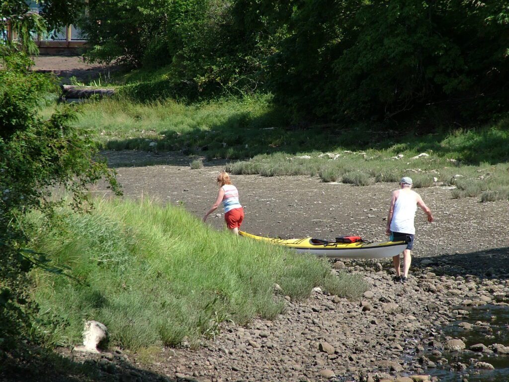 image of bob carrying a kayak, deep bay, vancouver island, british columbia