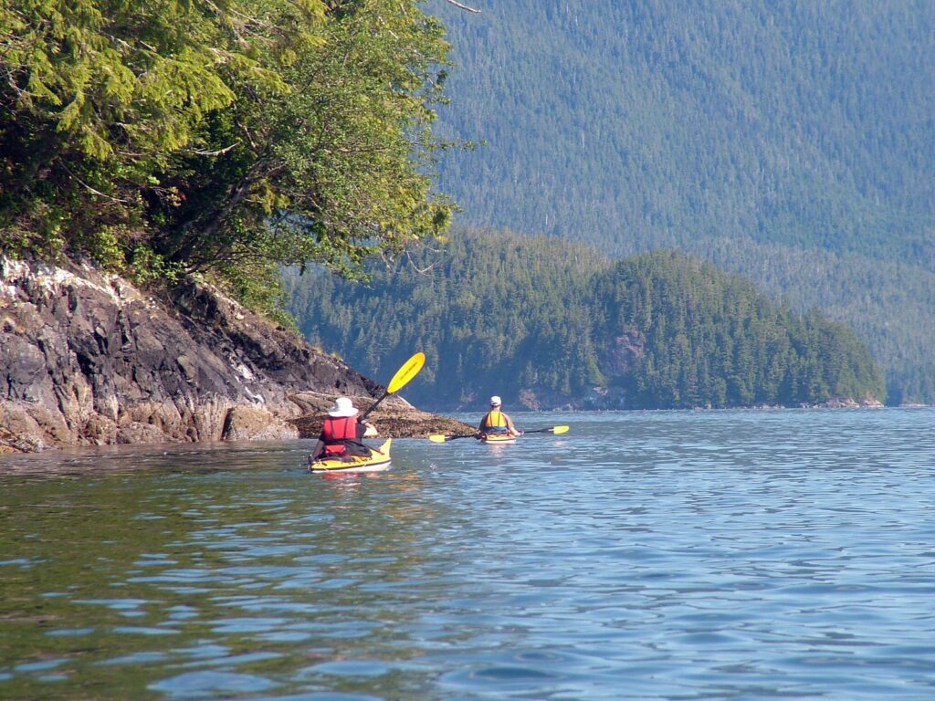 image of shoreline and kayakers, vargas island, british columbia