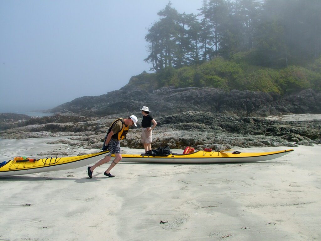 image of kayakers pulling up on a beach, vargas island, british columbia