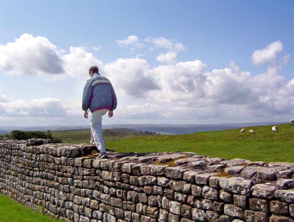 image of a person walking on Hadrian's Wall, the Great Whin Sill, near Housesteads, England 