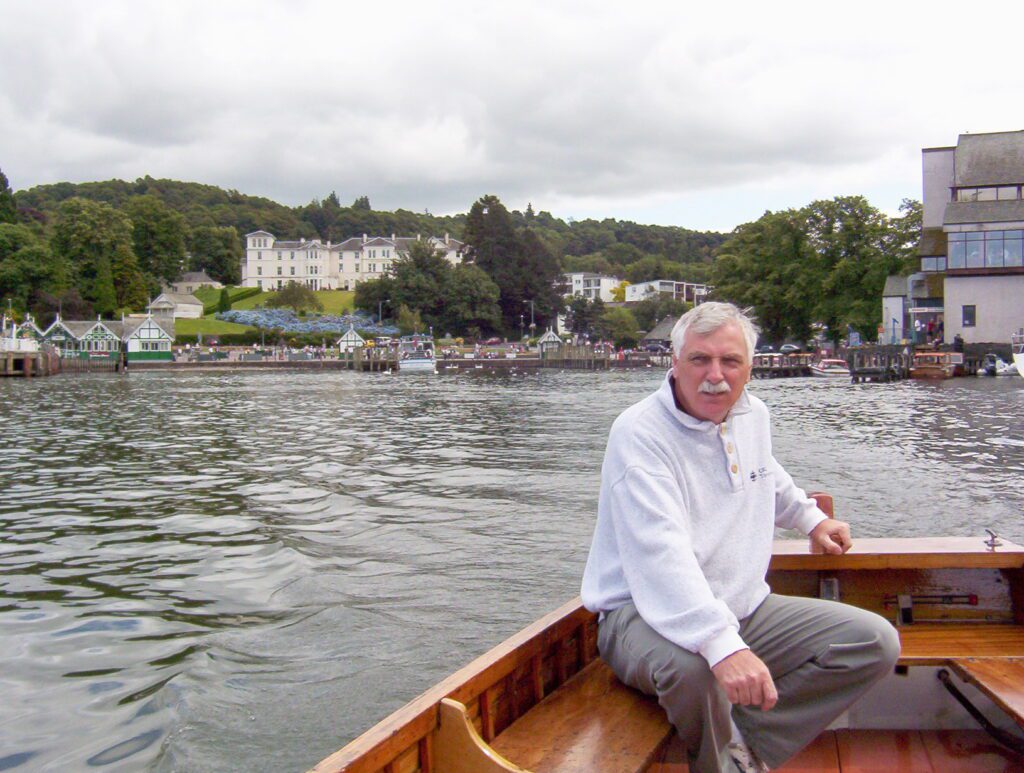 image of bob helming a cedar-stripped motorboat, Bowness-on-Windermere, Lake Windermere, Lake District National Park, England