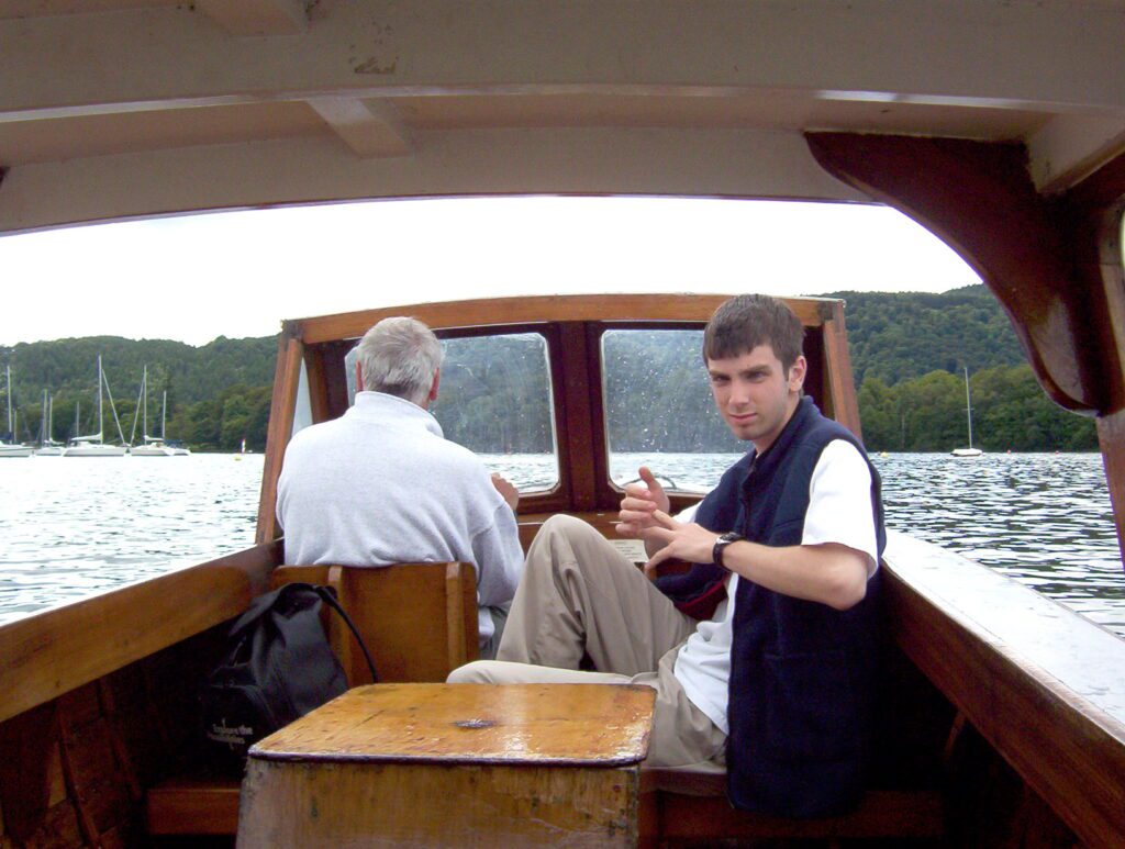image of Bob manning a classic wooden power boat, Bowness-on-Windermere, Lake Windermere, Lake District National Park, England