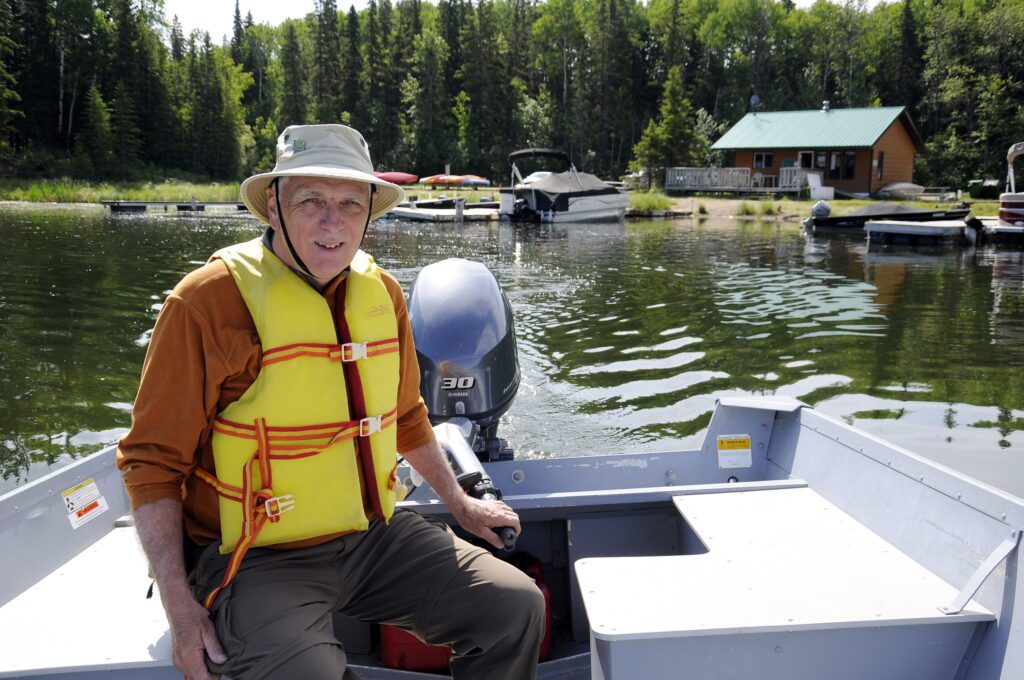 image of Bob helming a motorboat, Hanging Heart Lakes, Prince Albert National Park, Saskatchewan