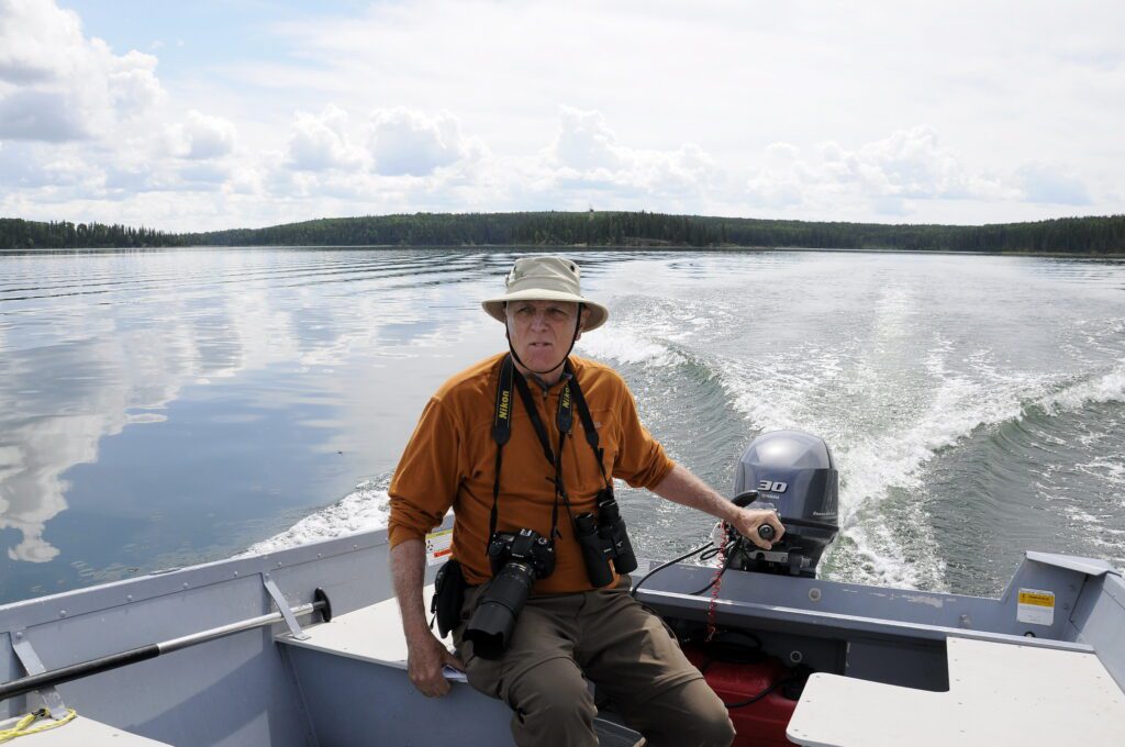 image of bob helming a motorboat, Hanging Heart Lakes, Prince Albert National Park, Saskatchewan